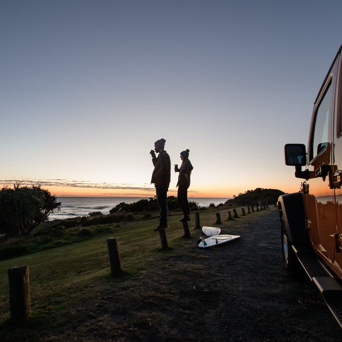 Two people rugged up checking the surf at sunrise