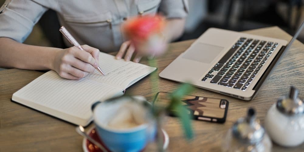 Woman planning digital content by taking notes