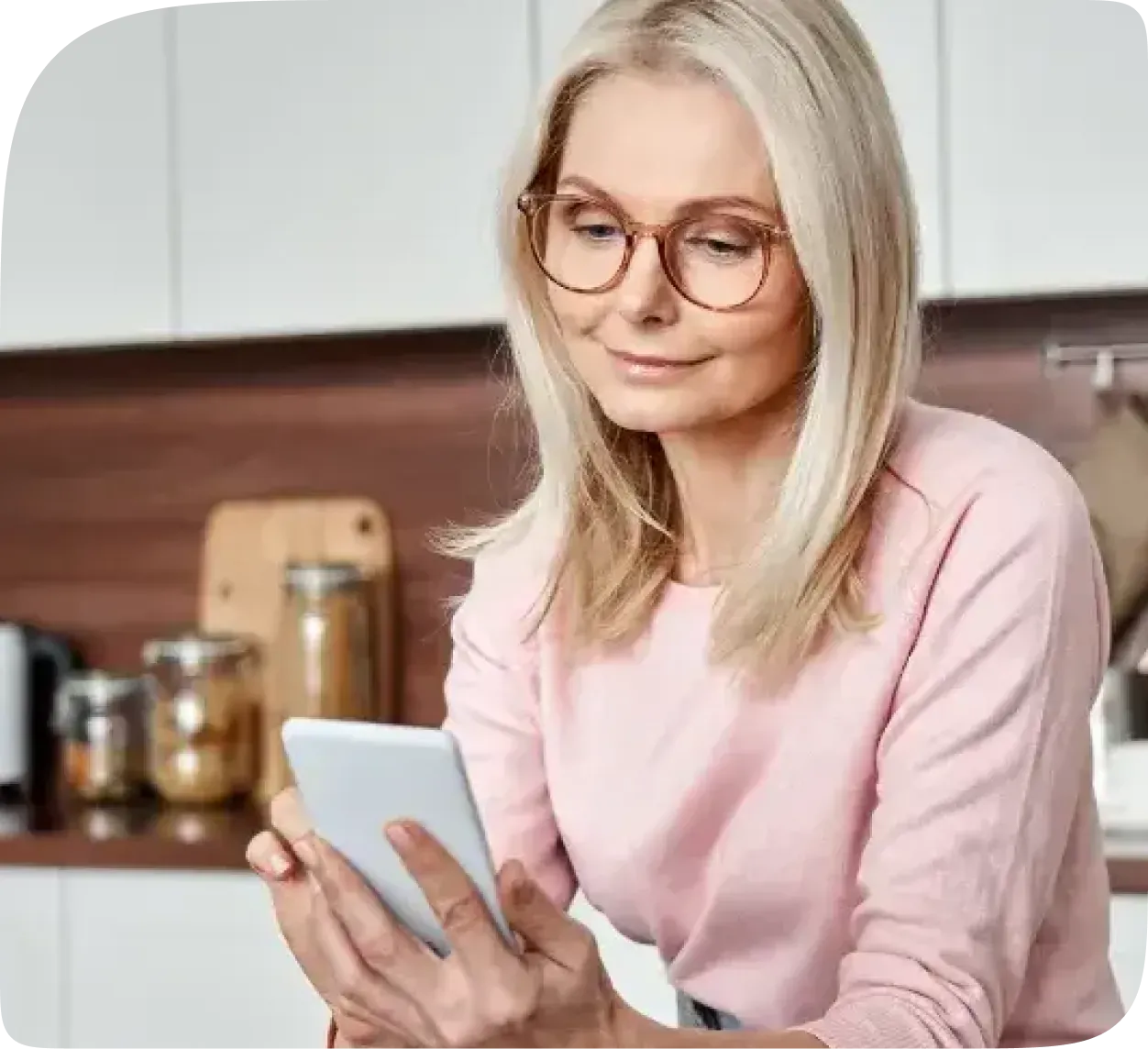 A woman reading on her phone in her kitchen