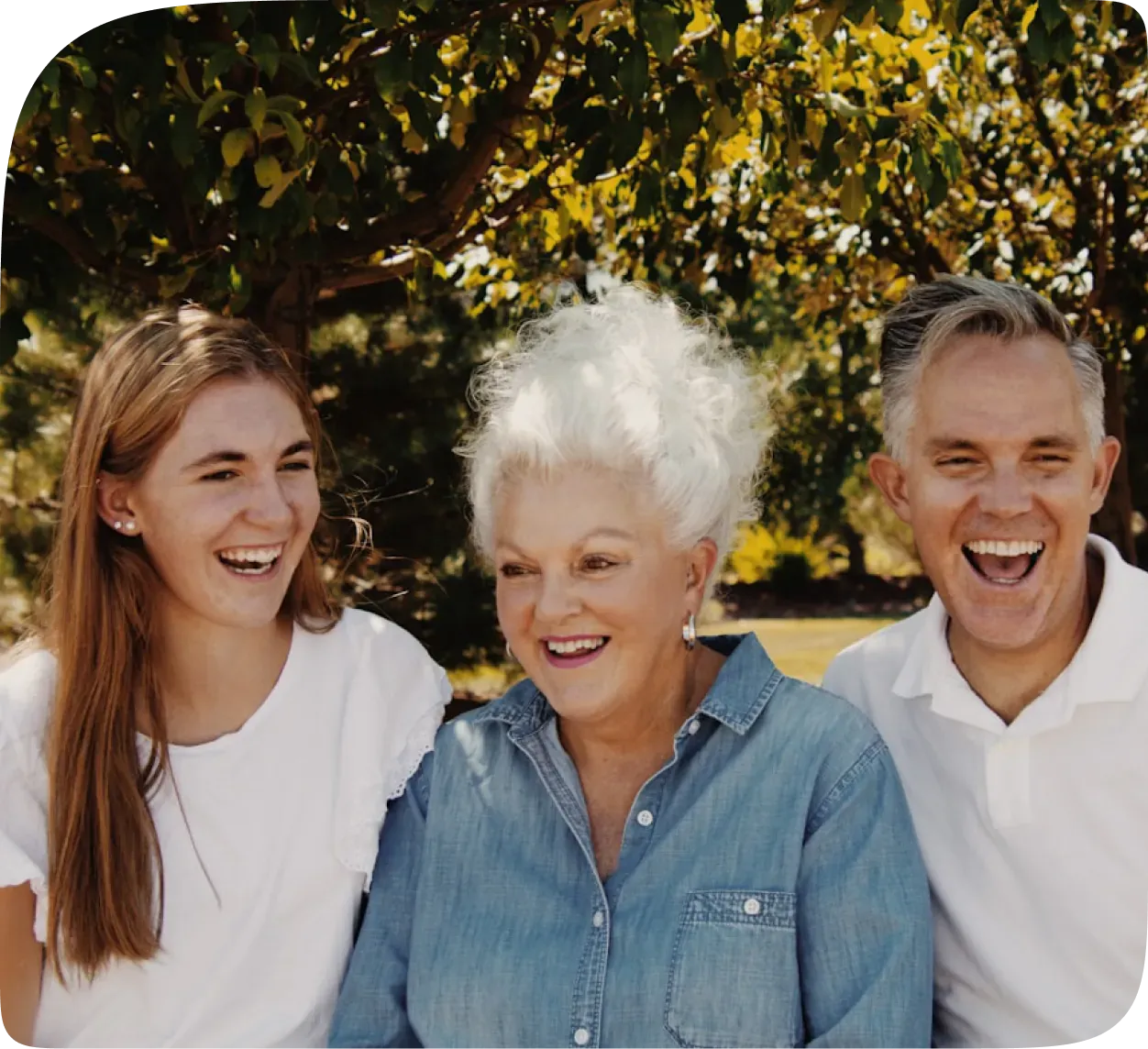 Three generations of a family laughing together outdoors