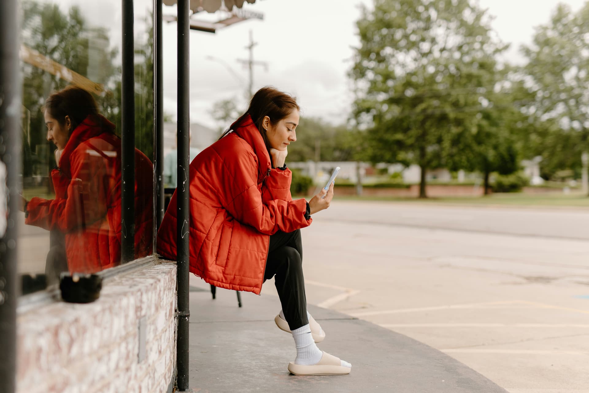 A woman sitting at a table looking down at her phone