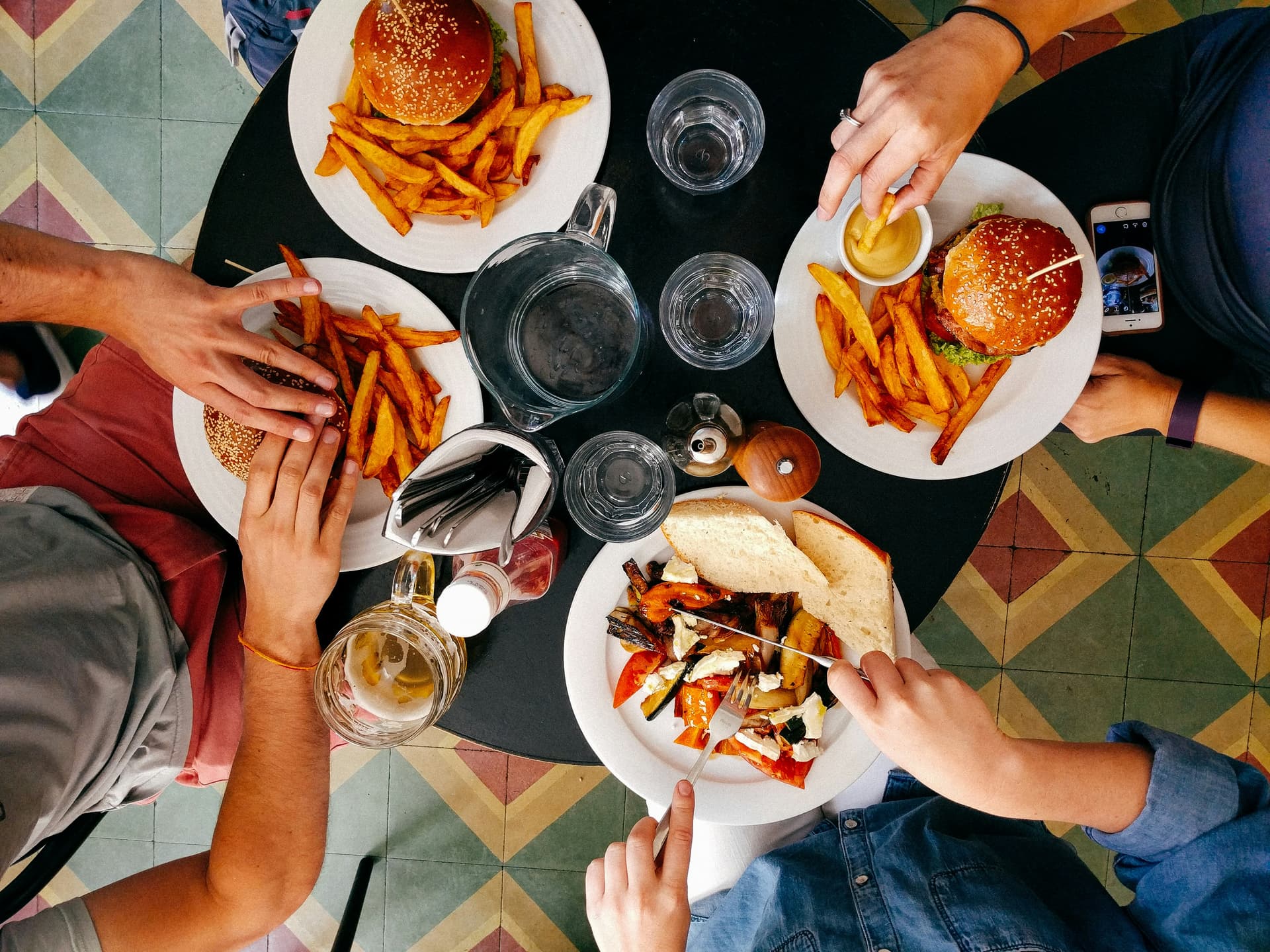 four people sharing food across a table