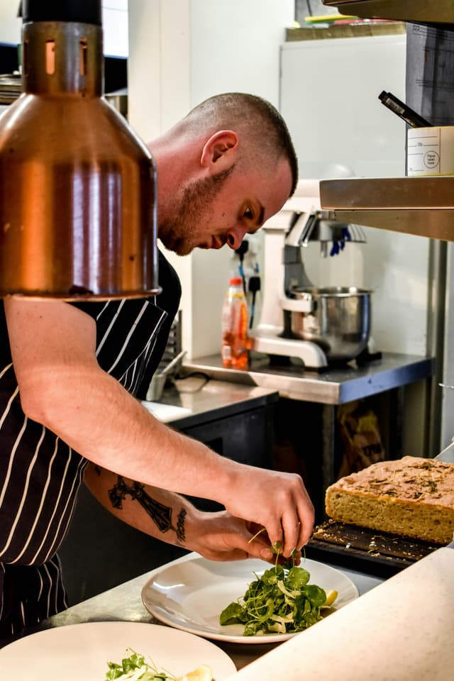 chef plating up food in a restaurant kitchen